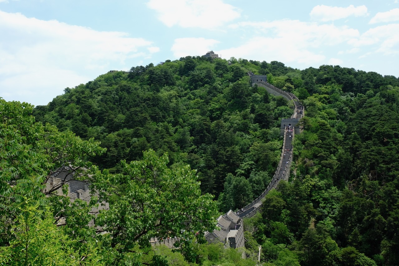 The Great Wall climbing steeply over green mountain ridges