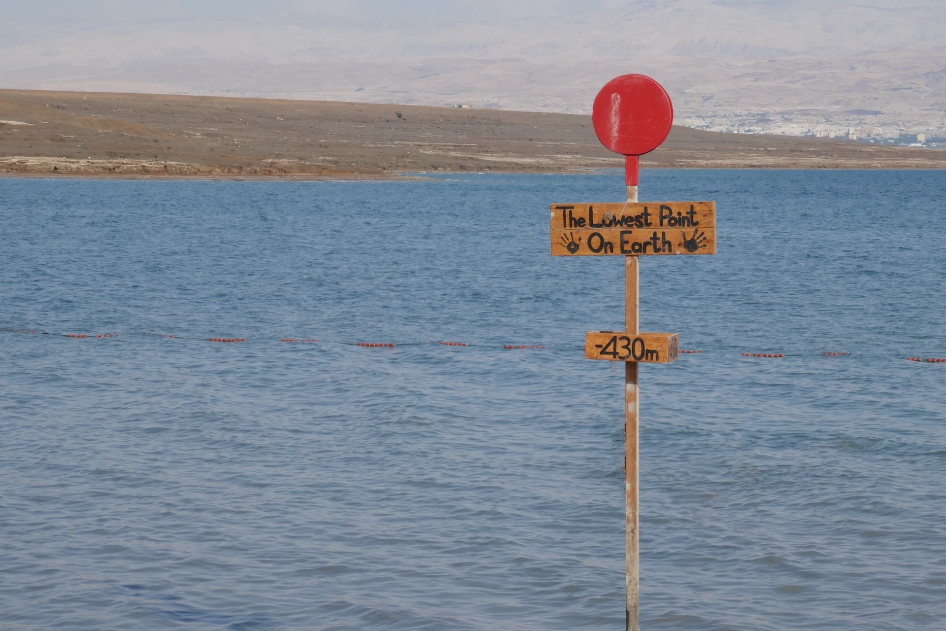 Sign marking the lowest point on Earth at the shore of the Dead Sea